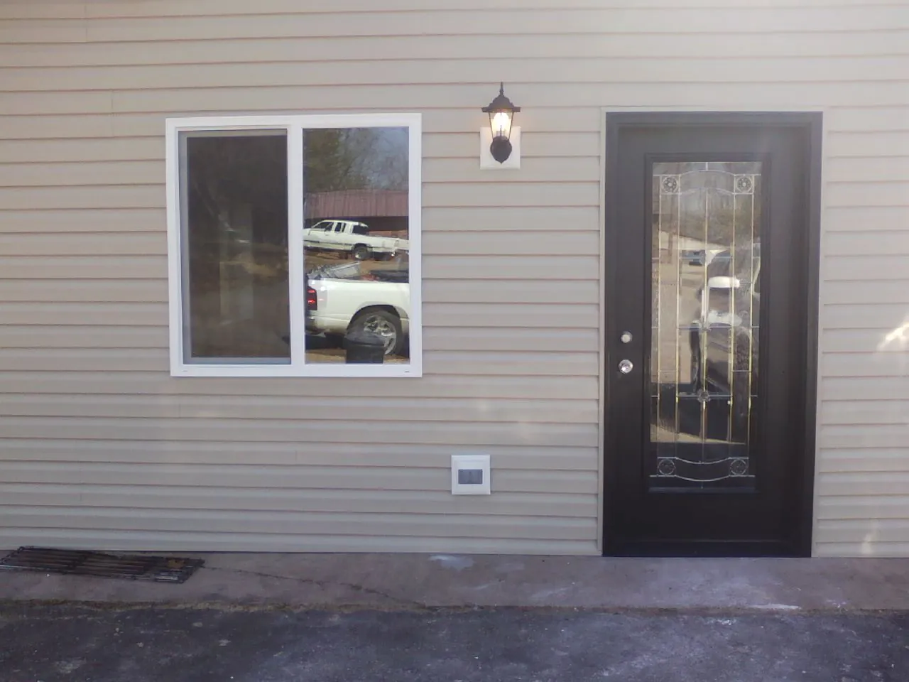 New siding, window and entry door on the side of an addition in Berry