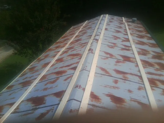 Rusted metal roof panels with new wood purlins before replacement — Storm Damage Roof Repair in Berry by Roofing Brothers