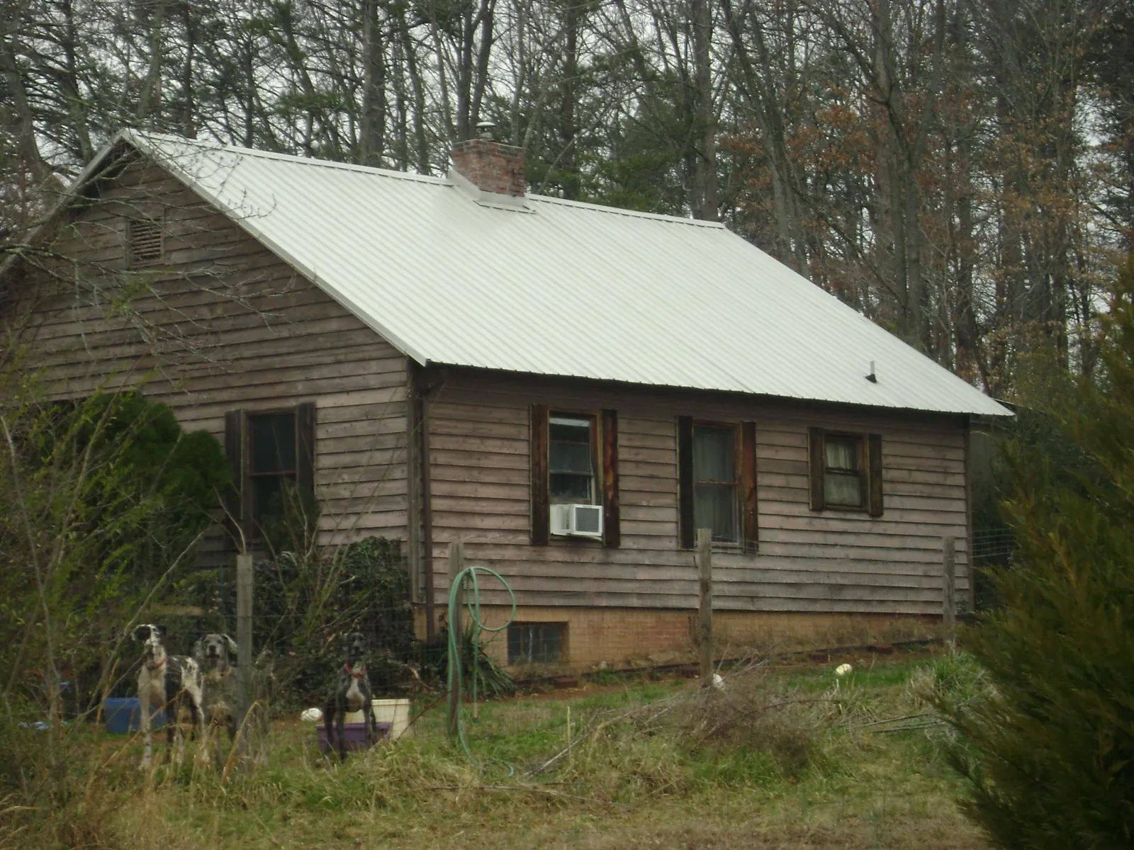 White metal roof on an old wood sided farmhouse, from a Metal Roof Installation job in Berry